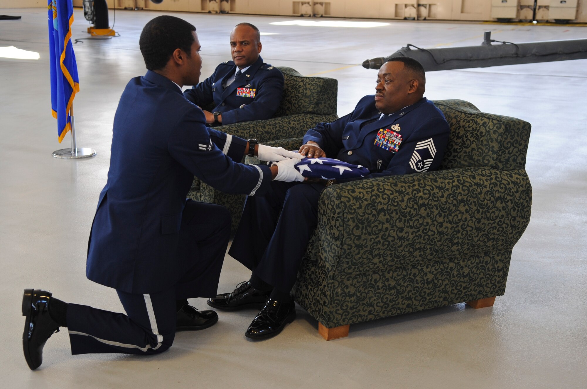 U.S. Air Force Airman 1st Class Glynn Finnie, Moody AFB Honor Guard, presents the flag to Chief Master Sgt. Kenneth Lilly, 23rd Wing weapons manager, during his retirement ceremony at Moody Air Force Base, Ga., Dec. 19, 2011. Lilly impacted many young airmen by encouraging them to step out of their comfort zone and to exceed.(U.S. Air Force photo by Airman 1st Class Olivia Dominique/Released)