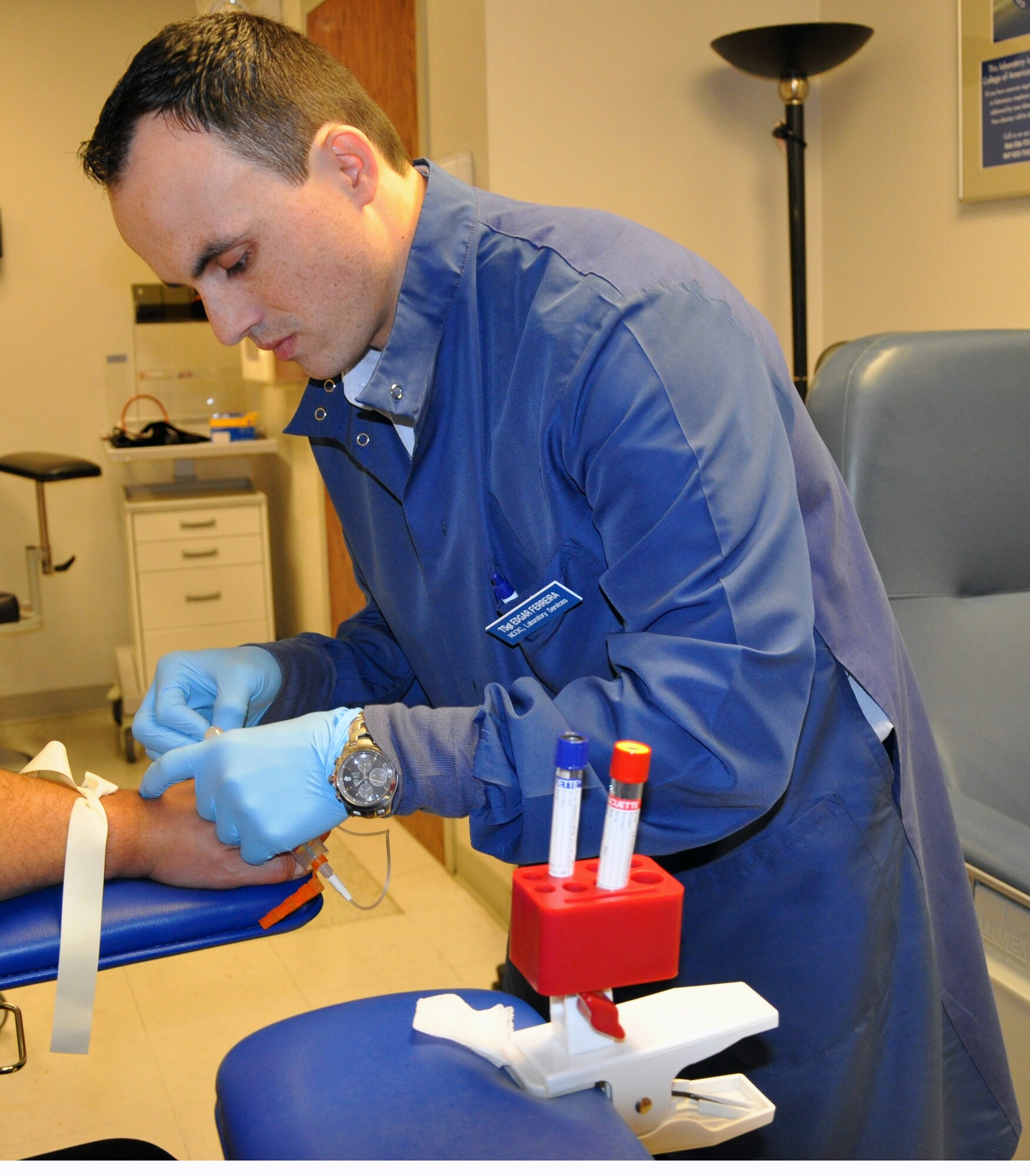 LAUGHLIN AIR FORCE BASE, Texas— Tech. Sgt. Edgar Ferreira, 47th Medical Support Squadron NCO in-charge of laboratory services, draws blood from a patient here Dec. 19. Ferreira was the victim of a drunk driver Dec. 7, 2007, an event that left him with a compound femur fracture and two broken knee caps which he has made a full recovery from. (U.S. Air Force photo/2nd Lt. James Ramirez)