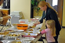 LAUGHLIN AIR FORCE BASE, Texas - - Sigrid Martini and her daughter make cookie bags at the Officer’s Spouses Club Cookie Caper here Dec. 14 for single active duty members stationed at Laughlin. Volunteer’s packed more than 500 dozen cookies to be distributed around base housing and the dorm rooms. (U.S. Air Force photo/Senior Airman Scott Saldukas)