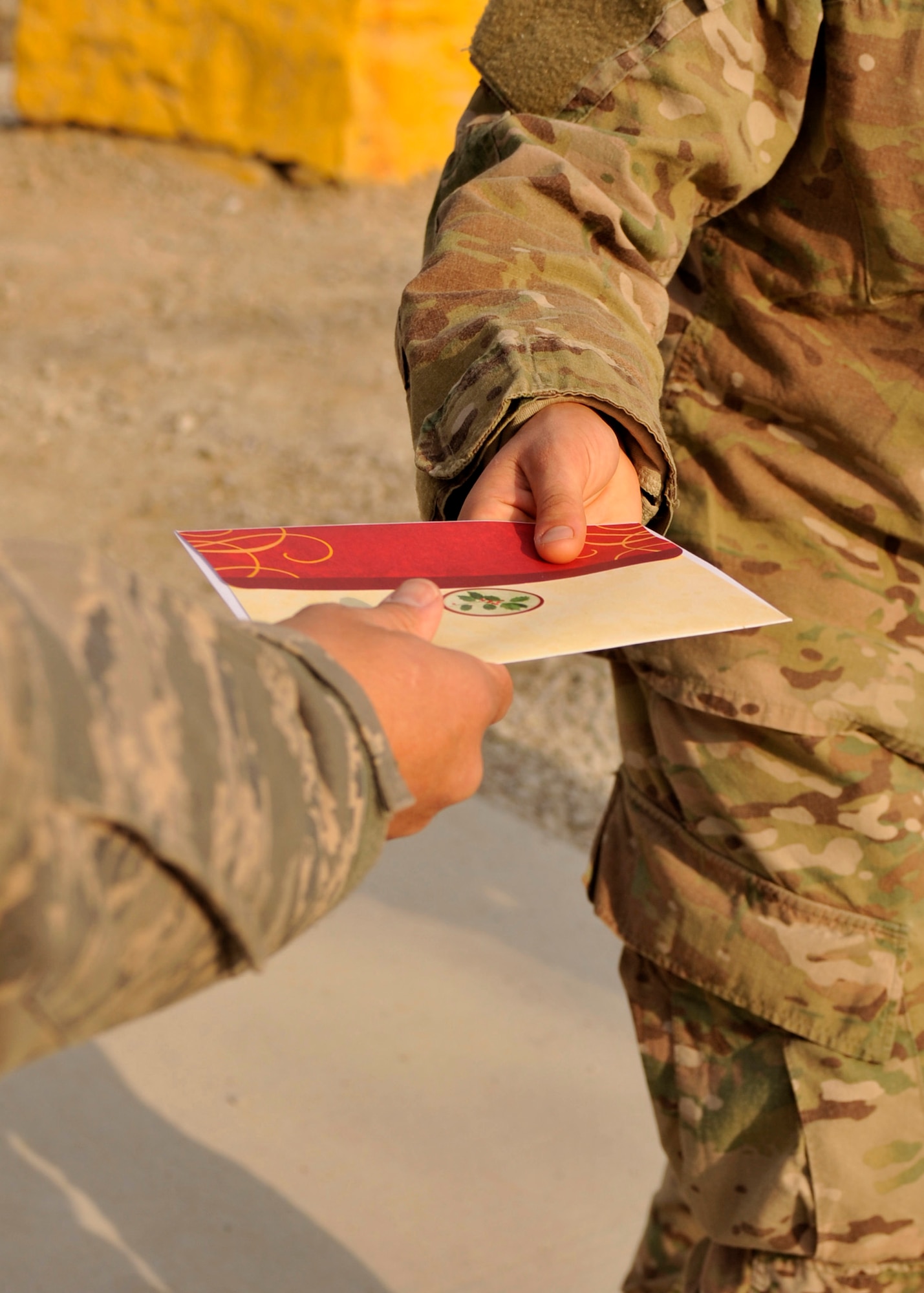BAGRAM AIRFIELD, Afghanistan – Staff Sgt. Matthew Reyes, 455th Expeditionary Security Forces Squadron, hands a Christmas card to another servicemember at Bagram Airfield, Afghanistan, Dec. 19, 2011. Reyes is a volunteer supporting Operation Merry Christmas, a program that shipped more than  14,000 Christmas cards to Bagram Airfield to be handed out to the servicemembers. (U.S. Air Force photo/ Airman 1st Class Ericka Engblom)