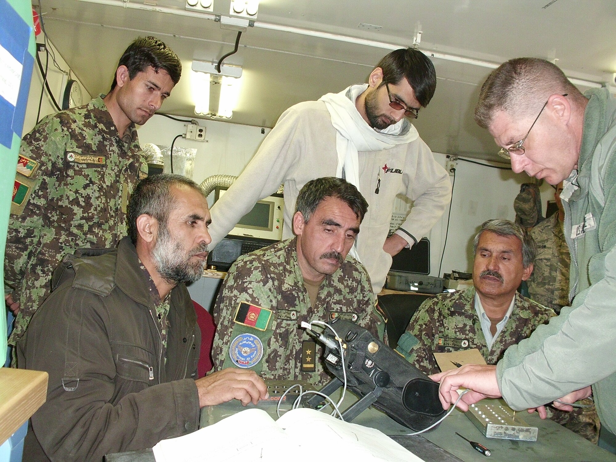 A U.S. Air Force Nondestructive Inspection technician demonstrates a technique to Afghan aircraft maintainers at Kandahar Air Base. (courtesy photo)