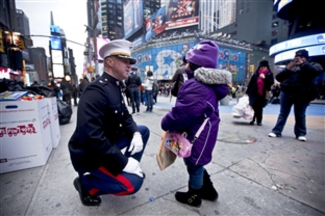 A Marine talks with a child as Marines collect toys in Times Square as part of their Toys for Tots drive in New York, Dec. 19, 2011. The Marines will load their tactical vehicles with toys collected from numerous drop-off locations in the city. The Marines are assigned to the 6th Communication Battalion, a Marine Forces Reserve unit based in Floyd Bennett Field, Brooklyn. Last year, Marines from the unit collected about 280,000 toys.