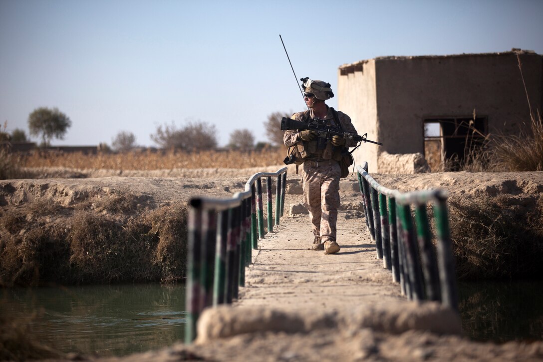 Lance Cpl. Joshua Prall, a 19-year-old rifleman with 3rd Platoon, Lima Company, 3rd Battalion, 3rd Marine Regiment and native of Syracuse, N.Y., scans the area while crossing a bridge during a partnered security patrol with Afghan National Army soldiers here, Dec. 18. On the patrol, the ANA and Marines interacted with local citizens and conducted a vehicle checkpoint. The Marines of “America’s Battalion” are aiding the Afghan National Security Forces in assuming security responsibilities over Helmand province’s Garmsir district. Their interoperability is designed to further the expansion of stability, development and legitimate governance of Afghanistan by defeating insurgent forces and helping secure the Afghan people.