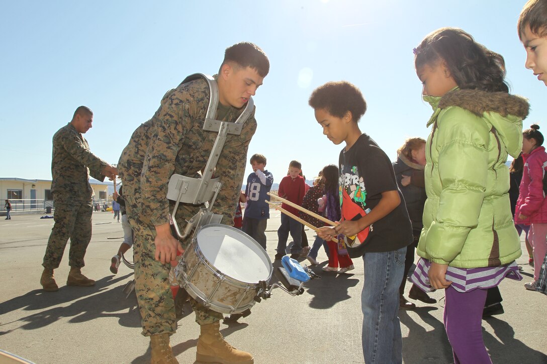 Cpl. Michael Perdomo-Hazen, percussionist, Combat Center Band, lets Condor Elementary School students play his drums during a performance by the “Bandini Brass Band” Dec. 6, 2011. The ensemble is part of the Combat Center Band. This was their last solo performance of the year.