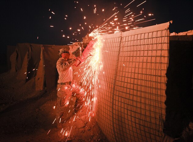 Cpl. James Hernandez, a combat engineer with Alpha Company, 9th Engineer Support Battalion, and a native of Goodyear, Ariz., uses an electric saw to dismantle a HESCO barrier at Firebase Saenz, Helmand province, Dec. 13. FB Saenz is the first of several patrol bases being demilitarized by the Marines of 9th ESB throughout the month of December.