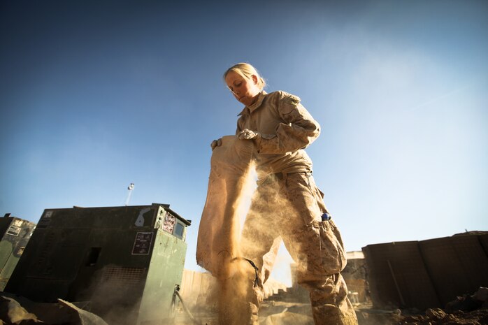 Lance Cpl. Jennifer Herman, a combat engineer with Alpha Company, 9th Engineer Support Battalion, and a native of Madison, Wis., helps move a piece of a HESCO barrier at Firebase Saenz, Helmand province, Dec. 14. FB Saenz is the first of several patrol bases being demilitarized by the Marines of 9th ESB throughout the month of December.