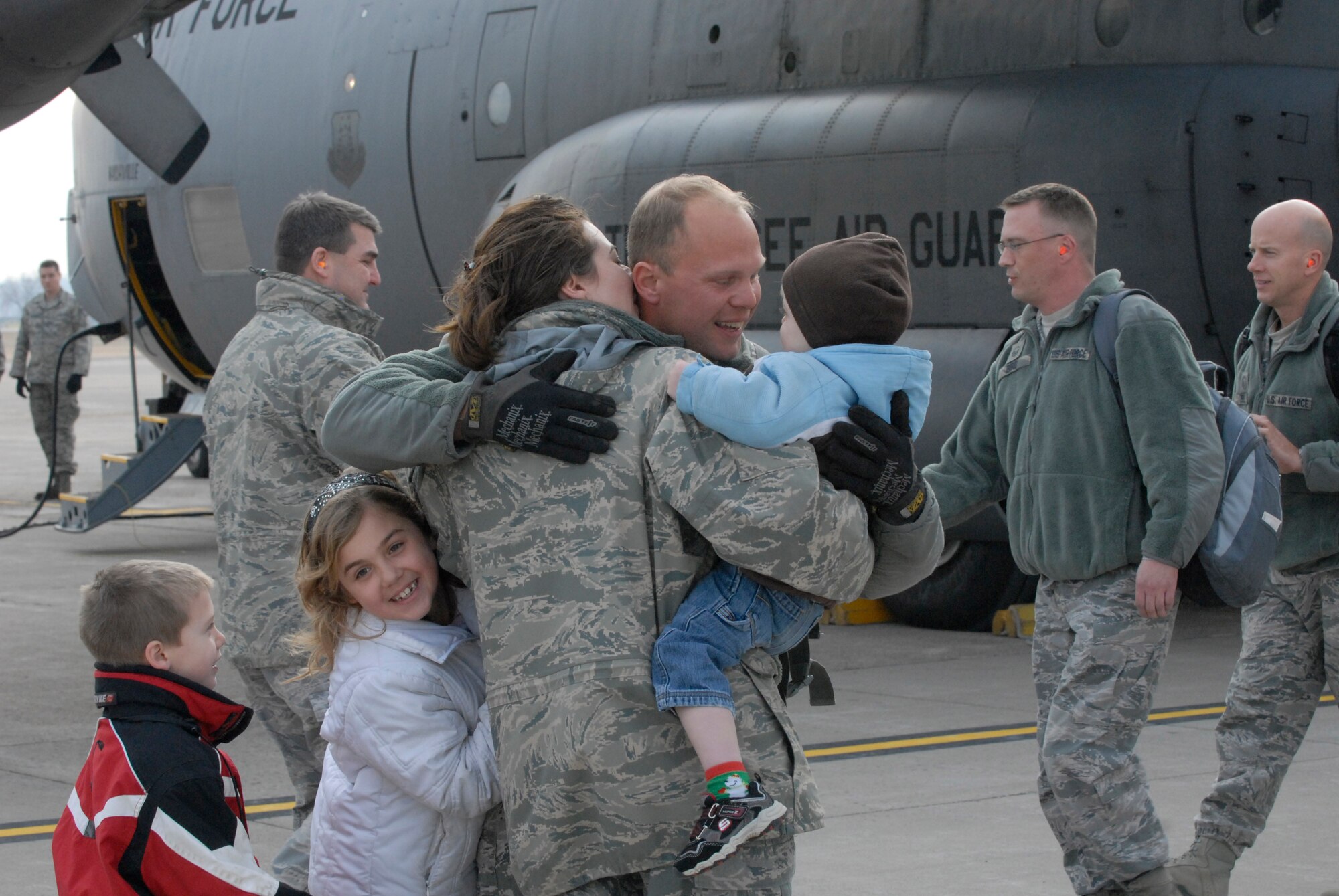 Joyful families embrace at the air guard base at the Minneapolis – St. Paul international airport on Dec. 21, 2011, as forty airmen disembark from an aircraft, returning from six months in Kuwait supporting Operation New Dawn. The airmen are from the 133rd Civil Engineer Squadron of the Minnesota Air National Guard and have been working with buildings and utilities at bases in Kuwait as the U. S. military pulled out of Iraq. Minnesota National Guard photo by Sgt. Johnny Angelo