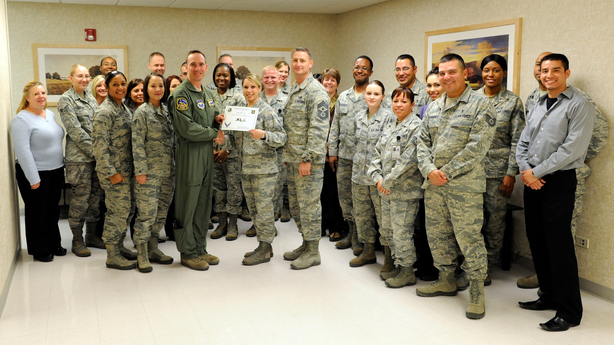 LAUGHLIN AIR FORCE BASE, Texas – Tech. Sgt. Nelly Cruz, 47th Medical Support Squadron NCO in charge of Tricare operations and patient administration, poses with Col. Tom Murphy, 47th Flying Training Wing commander, and Chief Master Sgt. Ray Devite, 47th FTW command chief, after being presented the XLer of the week award here Dec. 8. The XLer is a weekly award chosen by wing leadership and given to those who consistently make outstanding contributions to Laughlin and their unit. (U.S. Air Force photo/Airman 1st Class Nathan L. Maysonet)