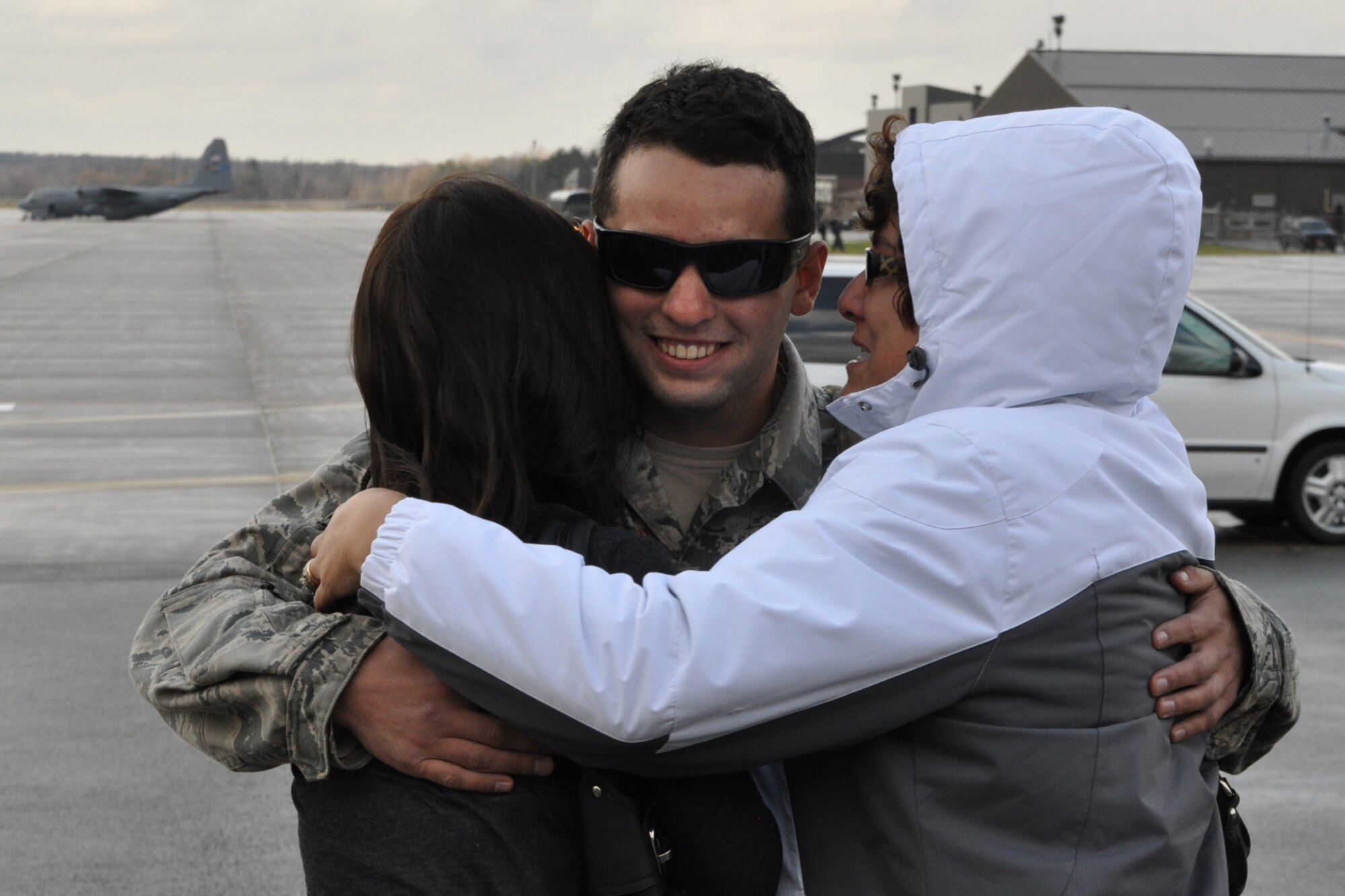 YOUNGSTOWN AIR RESERVE STATION, Ohio – Air Force Reserve Sr. Airman Alexander James, a member of the 910th Security Forces Squadron, hugs Amanda Dobrotka, his fiancée (left) and Tina James, his mother, on the flightline here, Dec. 21, 2011. James and five other 910th SFS Citizen Airmen were welcomed home by family, friends and fellow wing members upon their return to YARS from a six-month deployment at Shindand Air Base, the second largest airfield in Afghanistan. U.S. Air Force photo by Master Sgt. Bob Barko Jr.