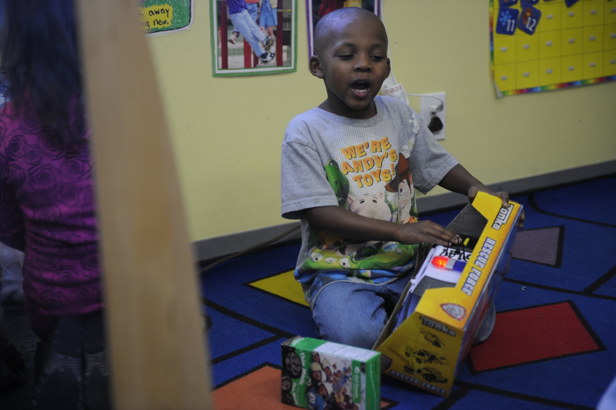 Jermaine who attends Liberty Park Child Development Center experiments with his new police car Dec. 12. (U.S. Air Force photo/Airman 1st Class Earlandez Young)
