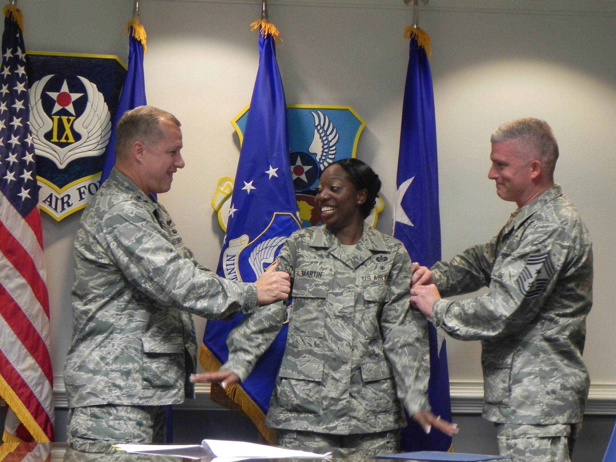 U.S. Air Force Maj. Gen. Lawrence Wells, 9th Air Force commander, and Command Chief Master Sergeant Robert Brooks, 9th Air Force command chief, tack technical sergeant stripes on Staff Sgt. Rononica Martin, 9th Air Force judge advocate, in a STEP promotion, Dec. 16, 2011, Shaw Air Force Base, S.C.  Wells surprised Martin with the STEP promotion when she thought she was there for a reenlistment. The Stripes for Exceptional Performers program recognizes outstanding individuals by instantly promoting them to staff, technical or master sergeant. (Courtesy Photo)