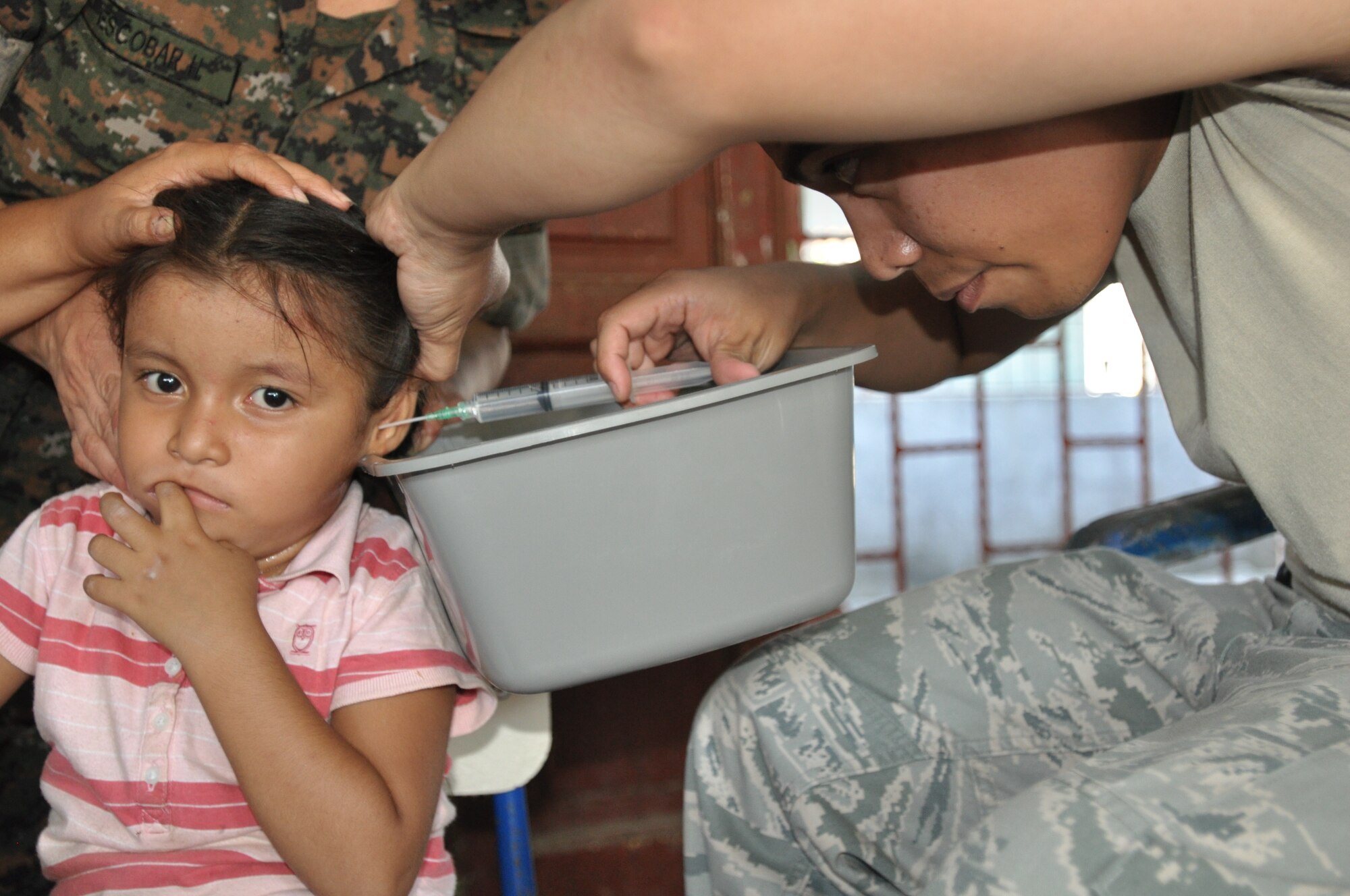 Tech. Sgt. Jose Libunao, a MEDEL EMT medic, conducts an ear flush on a young patient during the medical readiness and training exercise in El Codo, Guatemala Dec. 10, 2011. Libunao was part of a 22-member team from Joint Task Force-Bravo that provided medical care to more than 1,400 residents Dec. 8-13 in an isolated region of southwest Guatemala.  In fiscal year 2011, JTF-Bravo medical members conducted 15 MEDRETES treating more than 41,000 patients throughout Central America. (U.S. Air Force photo/Capt. Candice Allen)