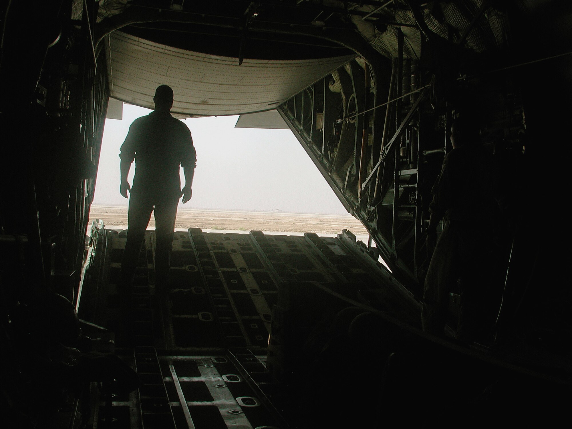 Senior Airman Aaron Hillenberg stands at the back of a C-130 Hercules while waiting to taxi from Basra International Airport, Iraq, on Oct. 21, 2003. C-130s are one of the main Air Force assets that perform missions out of Basra. Hillenberg is a C-130 loadmaster deployed from the 96th Airlift Squadron at Minneapolis International Airport. (U.S. Air Force photo/Master Sgt. Scott T. Sturkol)
