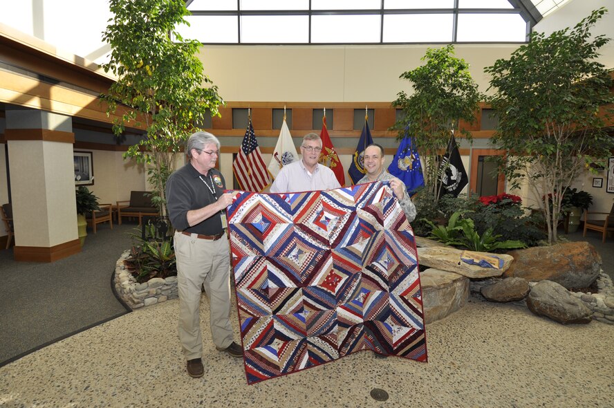 Edward Linde, Mortuary Operations Management System program manager, receives a Quilt of Valor for his work supporting Air Force Mortuary Affairs Operations at the Charles C. Carson Center, Dover Air Force Base, Del., Dec. 9, 2011. Linde served at Air Mobility Command Headquarters for more than 14 years and provided essential technical support for AFMAO. (U.S. Air Force photo/2nd Lt. Michael Gibson)