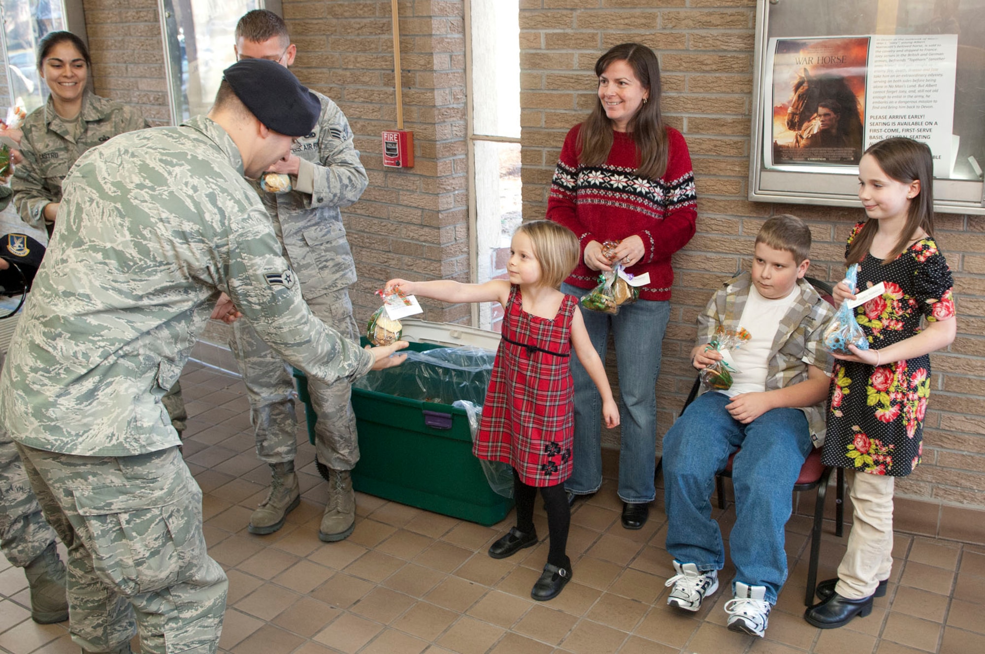 HANSCOM AIR FORCE BASE, Mass. – Katherine Gorton hands out cookies with her mom Robin Gorton and her brother Jakob and sister Audrey to Airmen after the Hanscom enlisted call at the base theatre on Dec. 16. The cookies were donated to the chapel and were distributed to spread holiday cheer to base personnel. (U.S. Air Force photo by Mark Wyatt)