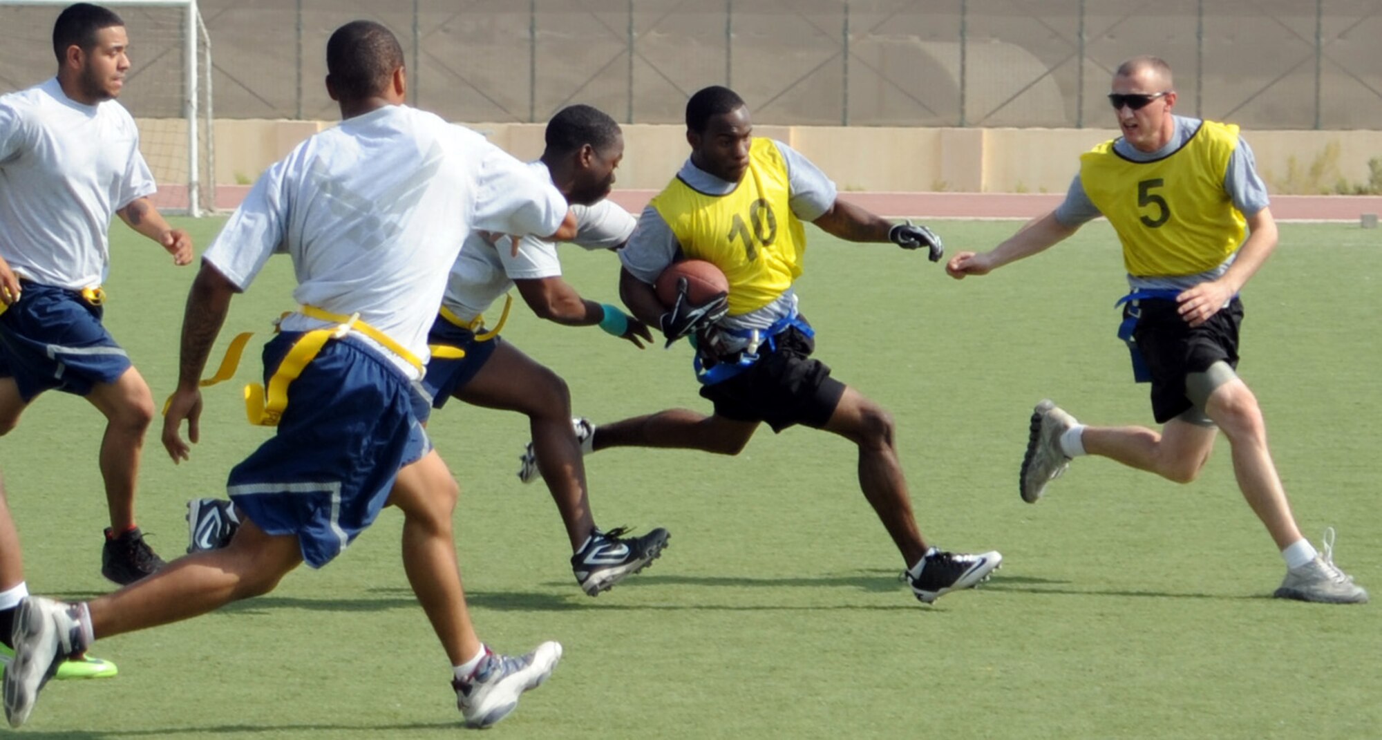 SOUTHWEST ASIA - A player from the Army team tries to slip by several Air Force team defenders during a football game Dec. 18, 2011, during the Holiday Games. In addition to football, teams played soccer, basketball, softball, billiards, table tennis and even competed in a video game competition. Members of the French air force participated in the combined cultural event as well.  (U.S. Air Force photo/Staff Sgt. J.G. Buzanowski)