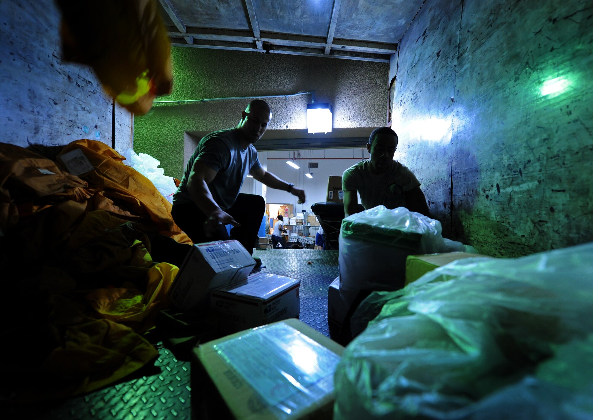 SOUTHWEST ASIA – Tech. Sgt. Ivan Abudo, 379th Expeditionary Communications Squadron Mail Control Activity chief and native of Dorado, Puerto Rico, (left) and Senior Airman Landon Wagner, a volunteer from the 379th Expeditionary Maintenance Squadron and native of Cleveland, unload mail in a cargo truck here Dec. 21, 2011. The MCA processed more than 48,000 pounds of mail Dec. 19-20, just in time for the holiday season. Abudo is deployed from Royal Air Force Menwith Hill, United Kingdom, and Wagner is deployed from Seymour Johnson Air Force Base, N.C. (U.S. Air Force photo/Staff Sgt. Nathanael Callon)