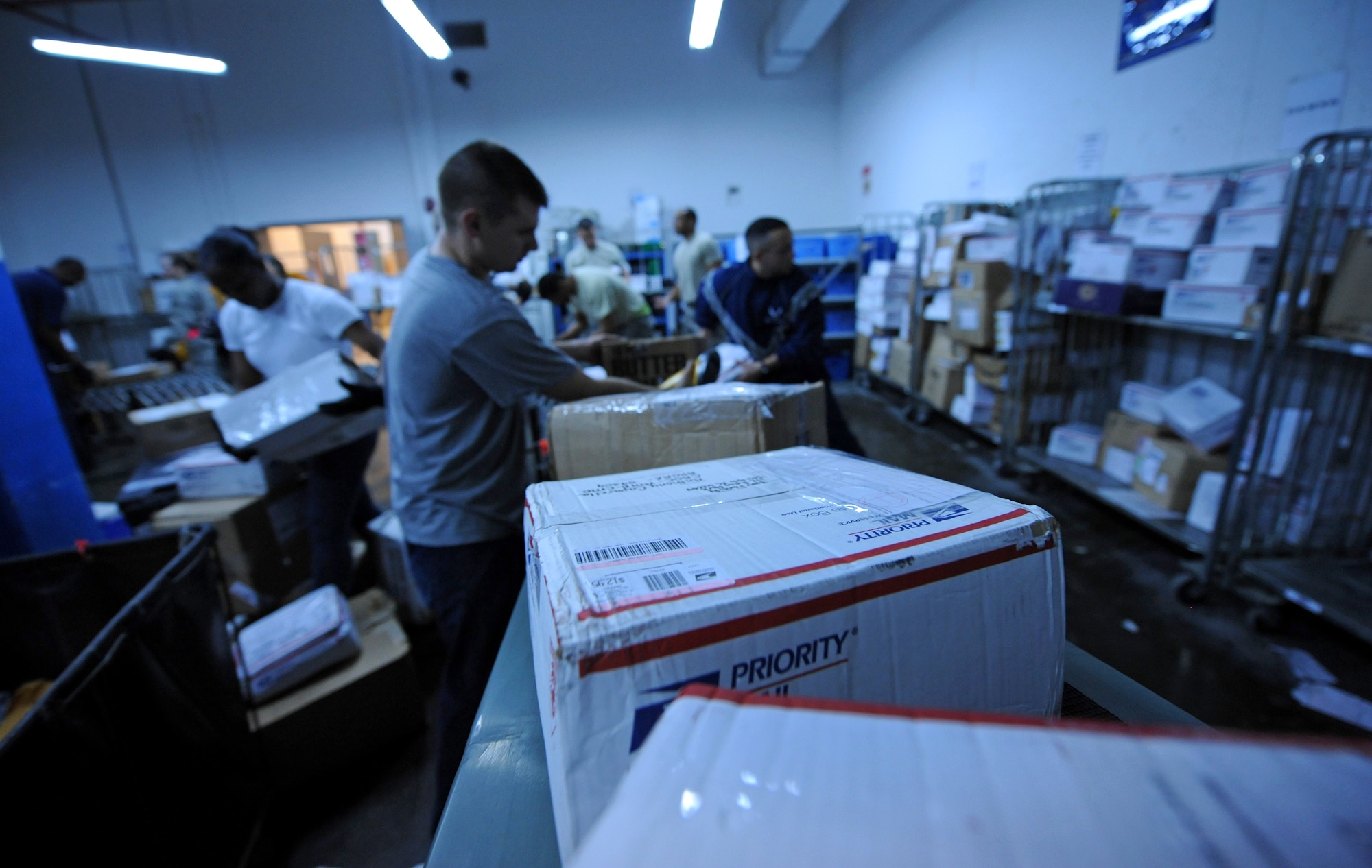 SOUTHWEST ASIA – Members of the 379th Expeditionary Communications Squadron Mail Control Activity and volunteers from the 379th Air Expeditionary Wing process mail here Dec. 21, 2011. The MCA processed more than 48,000 pounds of mail Dec. 19-20. (U.S. Air Force photo/Staff Sgt. Nathanael Callon)