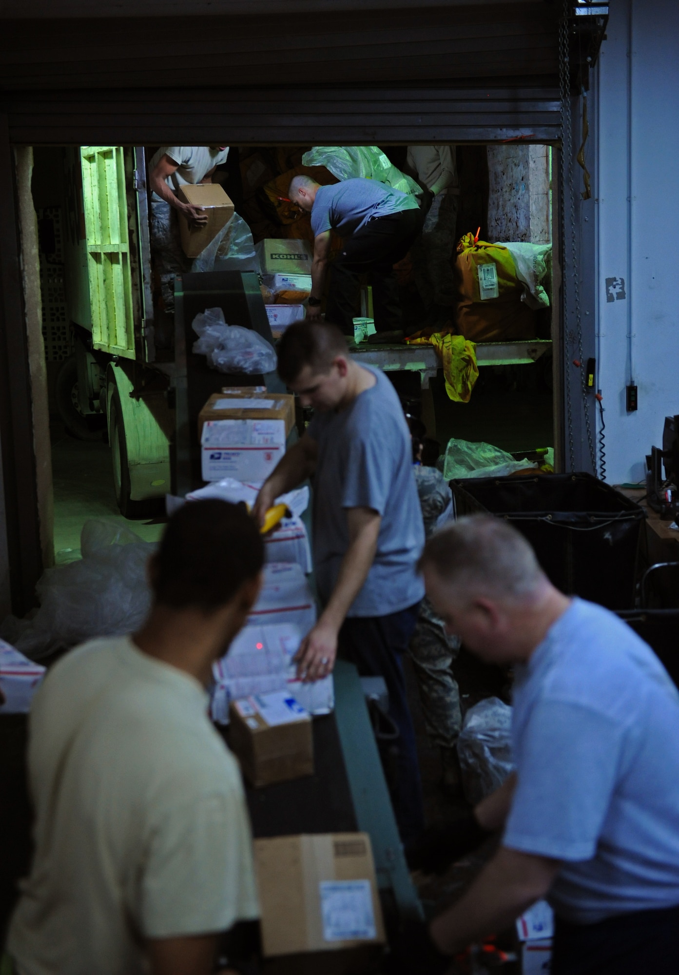 SOUTHWEST ASIA – Members of the 379th Expeditionary Communications Squadron Mail Control Activity and volunteers from the 379th Air Expeditionary Wing unload a truck filled with mail here Dec. 21, 2011. Dec. 19-20 are typically the busiest processing days for mail centers across the United States, and the MCA here has processed more mail in these two days than during an average work week. (U.S. Air Force photo/Staff Sgt. Nathanael Callon)
