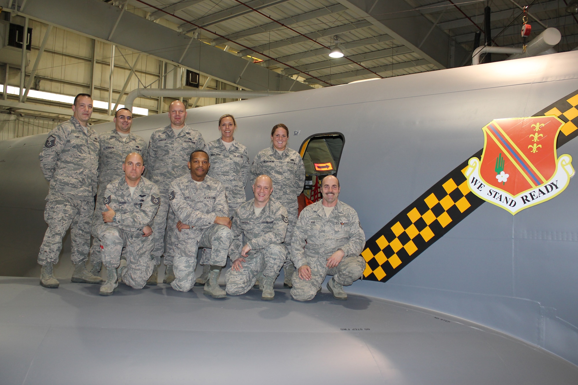 Airmen from the 191st Maintenance Squadron are seen on the wing of a KC-135 Stratotanker aircraft at Selfridge Air National Guard Base, Mich., Dec. 15,2011, next to a newly-painted 127th Wing shield and a checkerboard stripe. The aircraft was painted with the stripe and related detailing that honors both the heritage of the Michigan Air National Guard and the former Strategic Air Command, which once operated at Selfridge. (U.S. Air Force photo by TSgt. Dan Heaton)