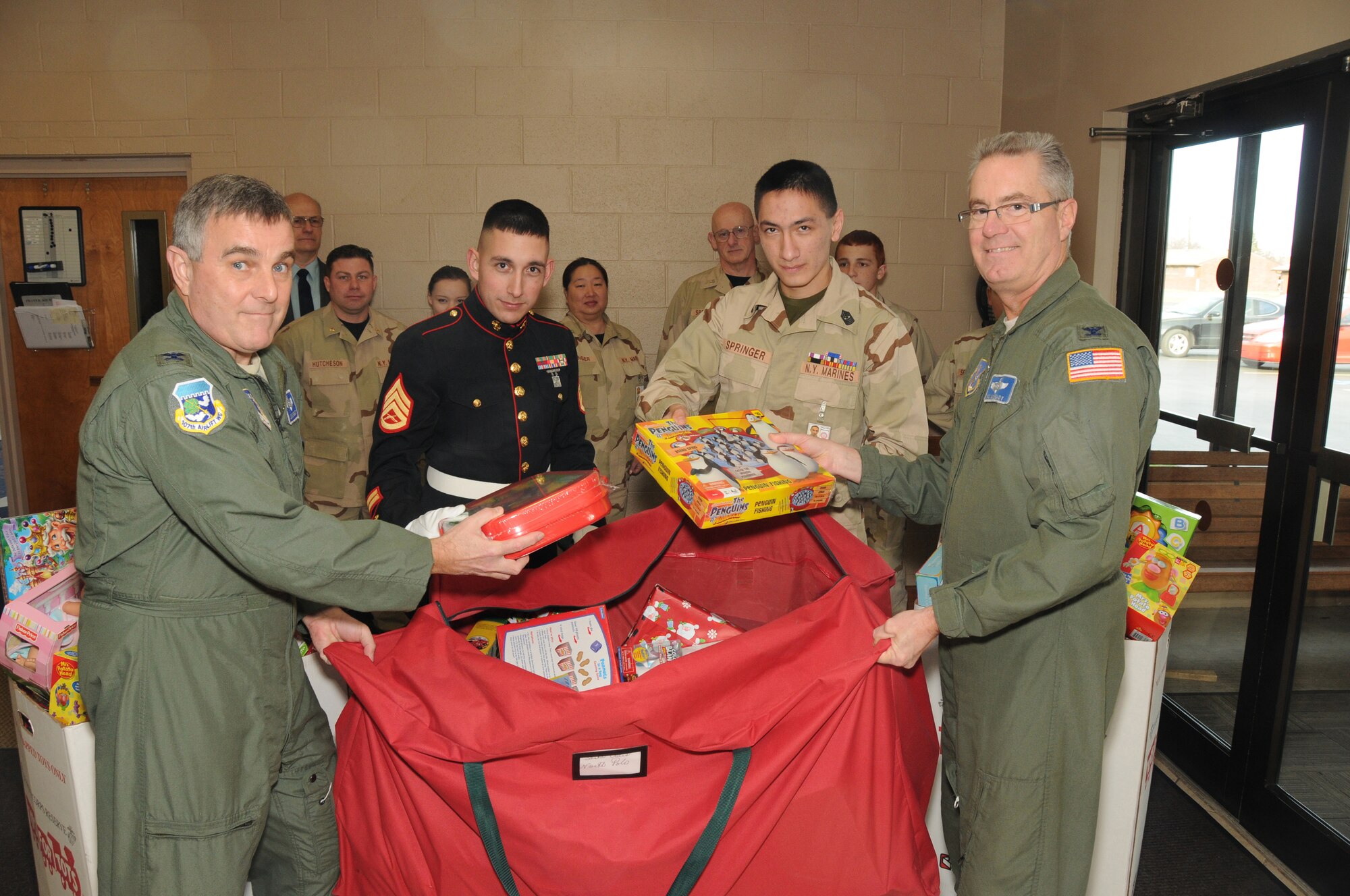 107th Airlift Wing helps out with the Marines Toys for Tots drive.  Col. John Higgins Vice Commander and Col. Jim McCready Commander hand off the toys to Staff Sgt. Erik Sanchez USMC Advisor, Sgt. Maj. Mathew Springer Marine Cadet on December 20, 2011 (Air Force Photo/Senior Master Sgt. Ray Lloyd)