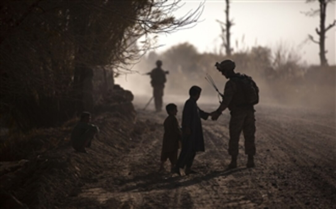 U.S. Marine Corps Sgt. Jeremy Holsten (right), a squad leader with 3rd Platoon, Lima Company, 3rd Battalion, 3rd Marine Regiment, interacts with local children during a partnered security patrol with Afghan National Army soldiers in Kuchiney Darvishan, Afghanistan, on Dec. 18, 2011.  The Marines aided the Afghan National Security Forces in assuming security responsibilities.  