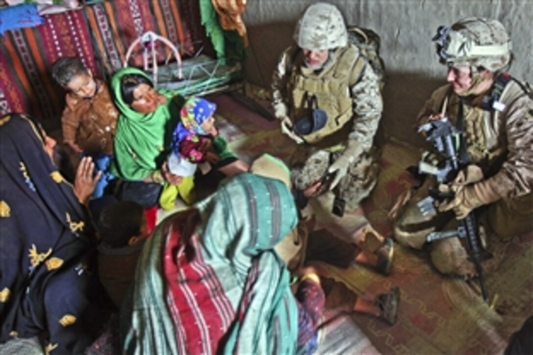 U.S. Navy Petty Officer 2nd Class Kimberly Ryan, right, visits with Afghan women at their home in Tughay village in the Sangin district of Afghanistan's Helmand province, Dec. 6, 2011. Ryan is a team member assigned to Female Engagement Team 8.  