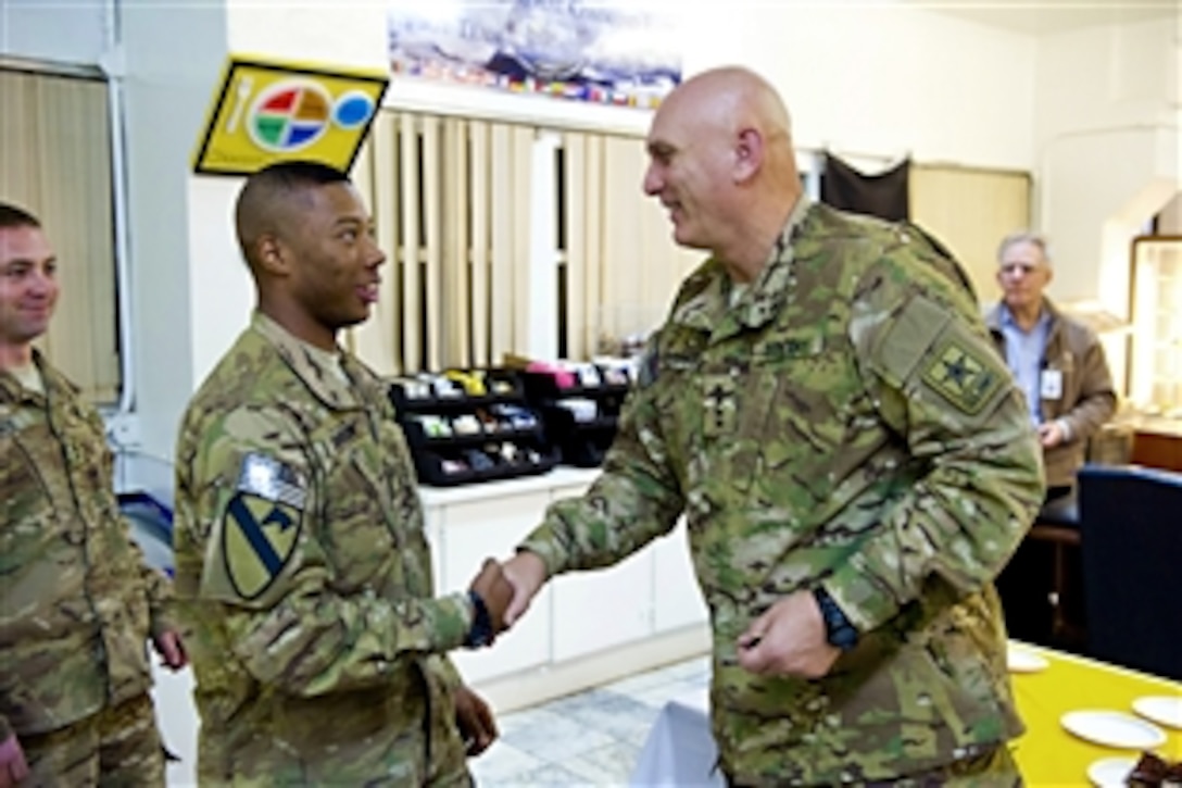 U.S. Army Chief of Staff Gen. Raymond T. Odierno shakes a soldier's hand as he presents commemorative coins to soldiers assigned to the 1st Cavalry Division at Regional Command-East  Headquarters, Bagram Airfield, Afghanistan Dec. 20, 2011.