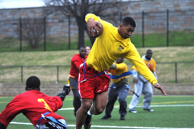 Brandon Mitchell, Headquarters & Service Company quarterback and cornerback, jukes past a defender during the second half of Marine Barracks Washington’s intramural flag-football championship here Dec. 21. Mitchell surpassed 150 all-purpose yards in the game. His performance on offense and defense was a major factor in Team H&S’s 20-12 victory. (Official Marine Corps Photo by Cpl. Austin Hazard/Released)::r::::n::