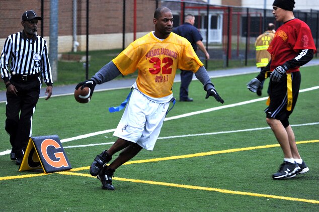 Alvin Neveaux, Headquarters & Service Company wide receiver, scores a touchdown late in the second half of Marine Barracks Washington’s intramural flag-football championship here Dec. 21. This final scoring drive was set up by scrambles from Brandon Mitchell, Headquarters & Service Company quarterback and cornerback. The touchdown sealed Team H&S’s victory, putting them up by a score. (Official Marine Corps Photo by Cpl. Austin Hazard/Released)::r::::n::