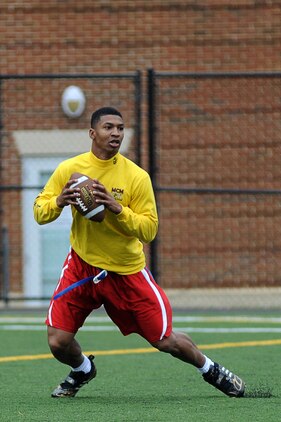 Brandon Mitchell, Headquarters & Service Company quarterback and cornerback, drops back for a pass during the first half of Marine Barracks Washington’s intramural flag-football championship Dec. 21. Mitchell threw for more than 100 yards in the game. His performance on offense and defense was a major factor in Team H&S’s 20-12 victory. (Official Marine Corps Photo by Lance Cpl. Mondo Lescaud/Released)::r::::n::