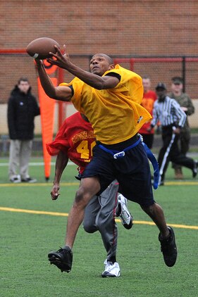David Wells, Headquarters & Service Company wide receiver, goes up for a reception during the second half of Marine Barracks Washington’s intramural flag-football championship Dec. 21. Wells turned the 10-yard pass into a 40-yard scamper after he made the fingertips catch. Big passing plays like this helped seal the 20-12 victory for Team H&S. (Official Marine Corps Photo by Lance Cpl. Mondo Lescaud/Released)::r::::n::