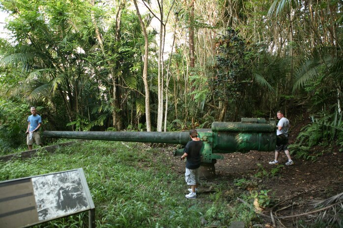 Marines with Marine Strike Fighter Attack Squadron 115 examine one of three Piti guns, Japanese-made Vickers-type Model 3 140 mm coastal defense guns, in their original emplacements during a comprehensive tour of battle sights and relics from the war in the Pacific during World War II here Dec 3. The weapons although intended for use primarily against ships and landing craft during World War II have never been fired. Piti guns weapons will remain silent for the rest of their existence.
