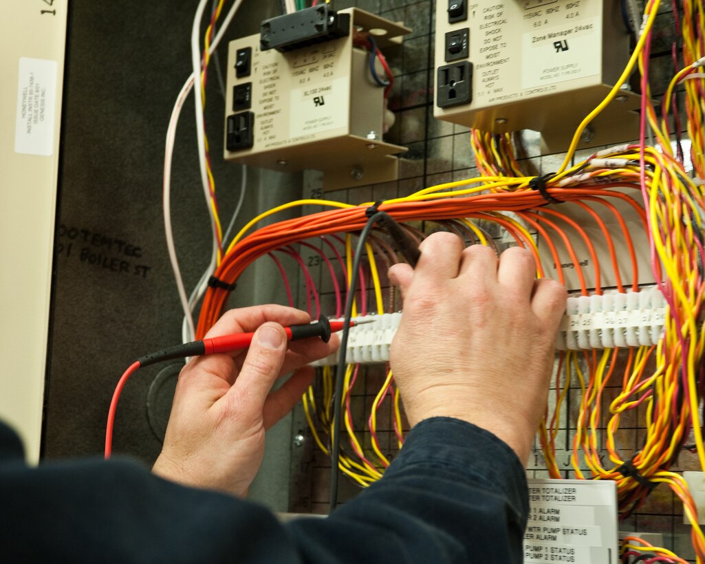 Clinton Peterson, 28th Civil Engineer Squadron industrial electronic control technician, connects the contact leads of a voltage meter to wires in a circuit box on Ellsworth Air Force Base, S.D., Dec. 22, 2011. If one of the circuits isn’t working properly, or if the temperature drops in a building, an alarm notifies the control shop to respond and fix the problem. (U.S. Air Force photo by Airman Alystria Maurer/Released)