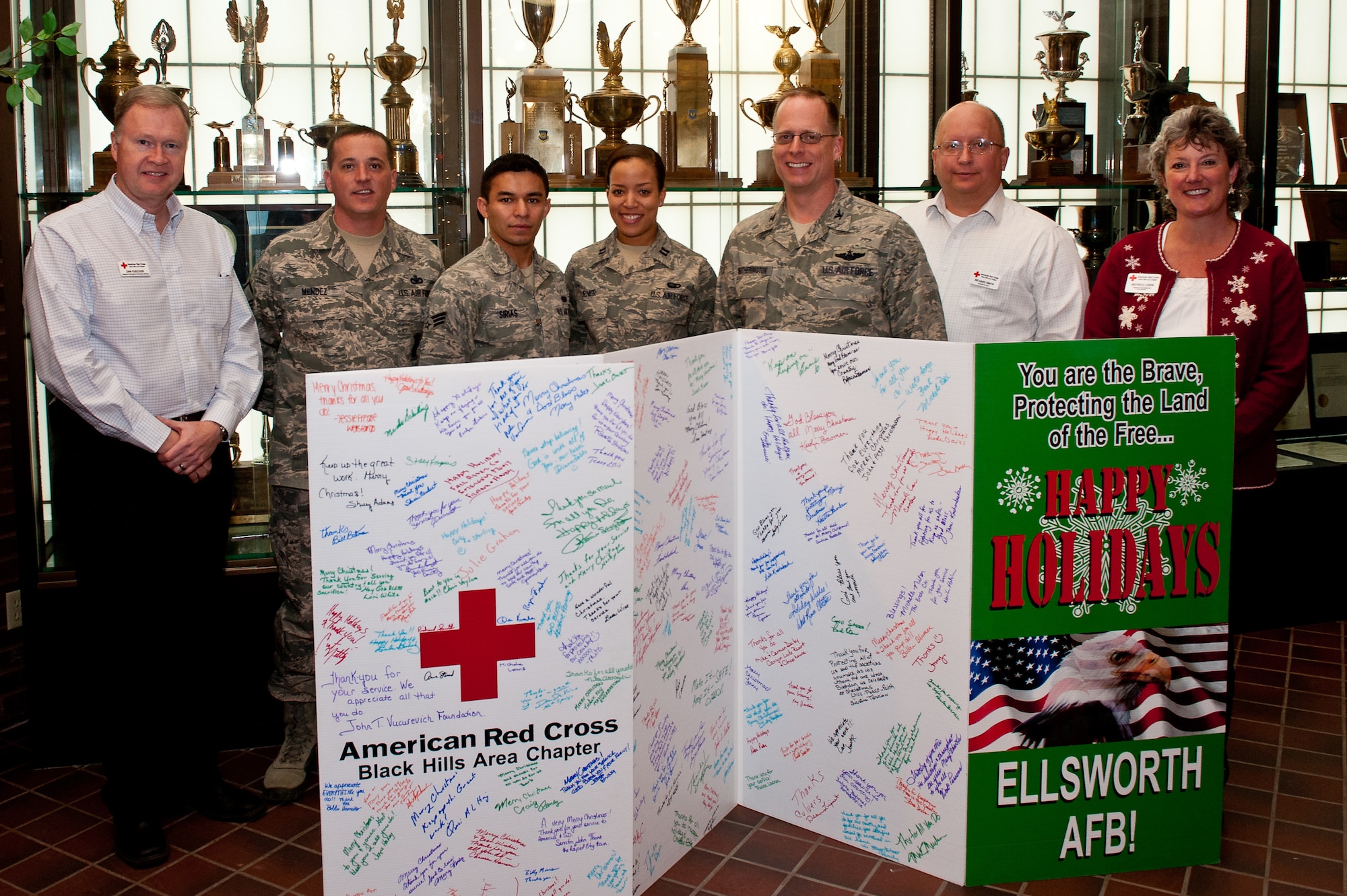 Col. Mark Weatherington, 28th Bomb Wing commander, accepts a large Christmas card on behalf of Ellsworth Air Force Base, S.D. from the staff of the American Red Cross of the Black Hills Area Dec. 21, 2011. The American Red Cross members traveled around western South Dakota allowing anyone to sign the card, thanking Ellsworth Airmen and wishing them a happy holiday season. (U.S. Air Force photo by Airman 1st Class Kate Thornton/Released)