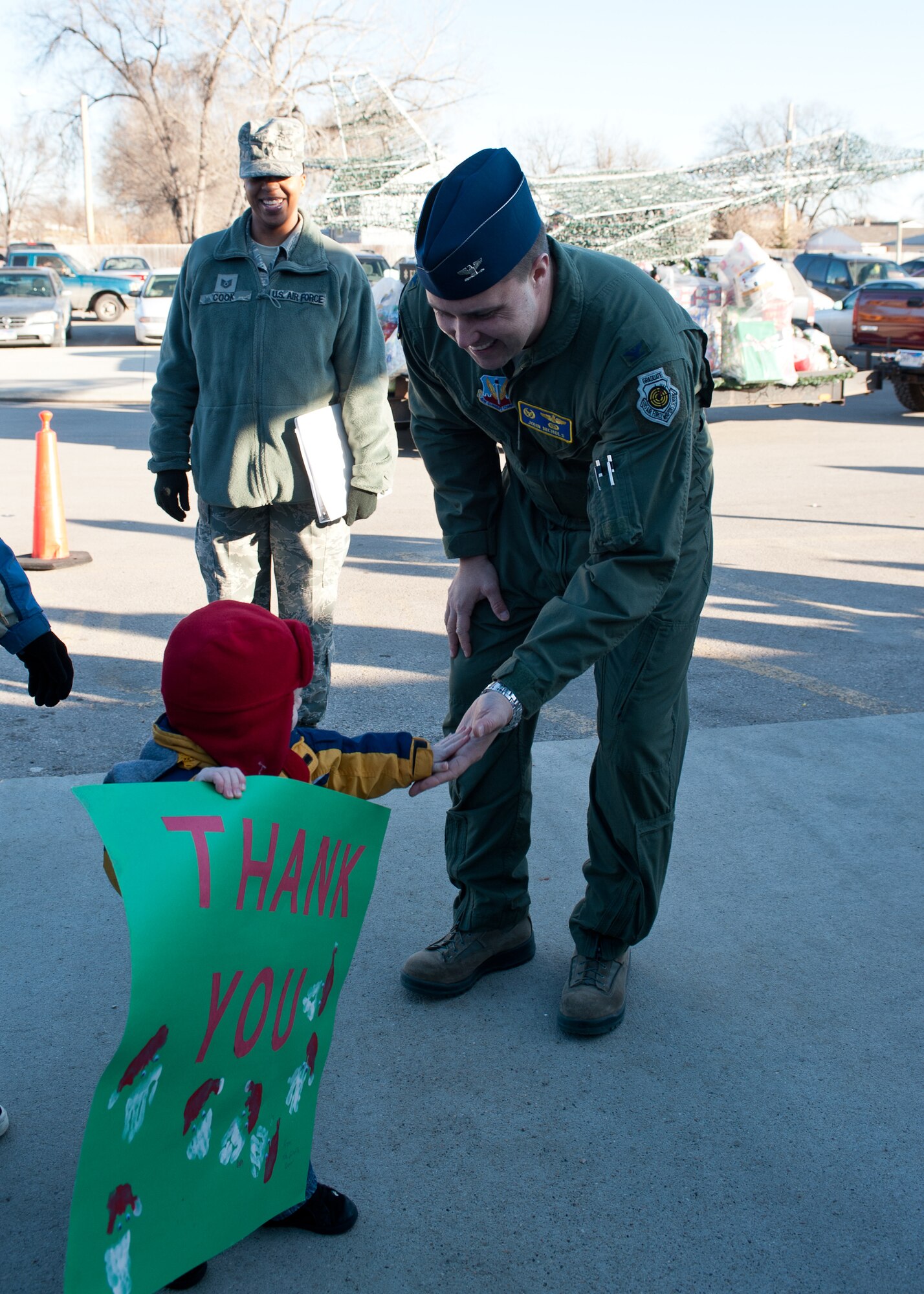 Col. John Nichols, 28th Operations Group commander, gets a high five from the children enrolled in the Youth & Family Services Child Care program during the 28th OG Angel Tree event in Rapid City, S.D., Dec. 15, 2011. More than 180 gifts were donated by members of the 28th OG, bringing joy to children throughout the community. (U.S. Air Force photo by Airman Alystria Maurer/Released)