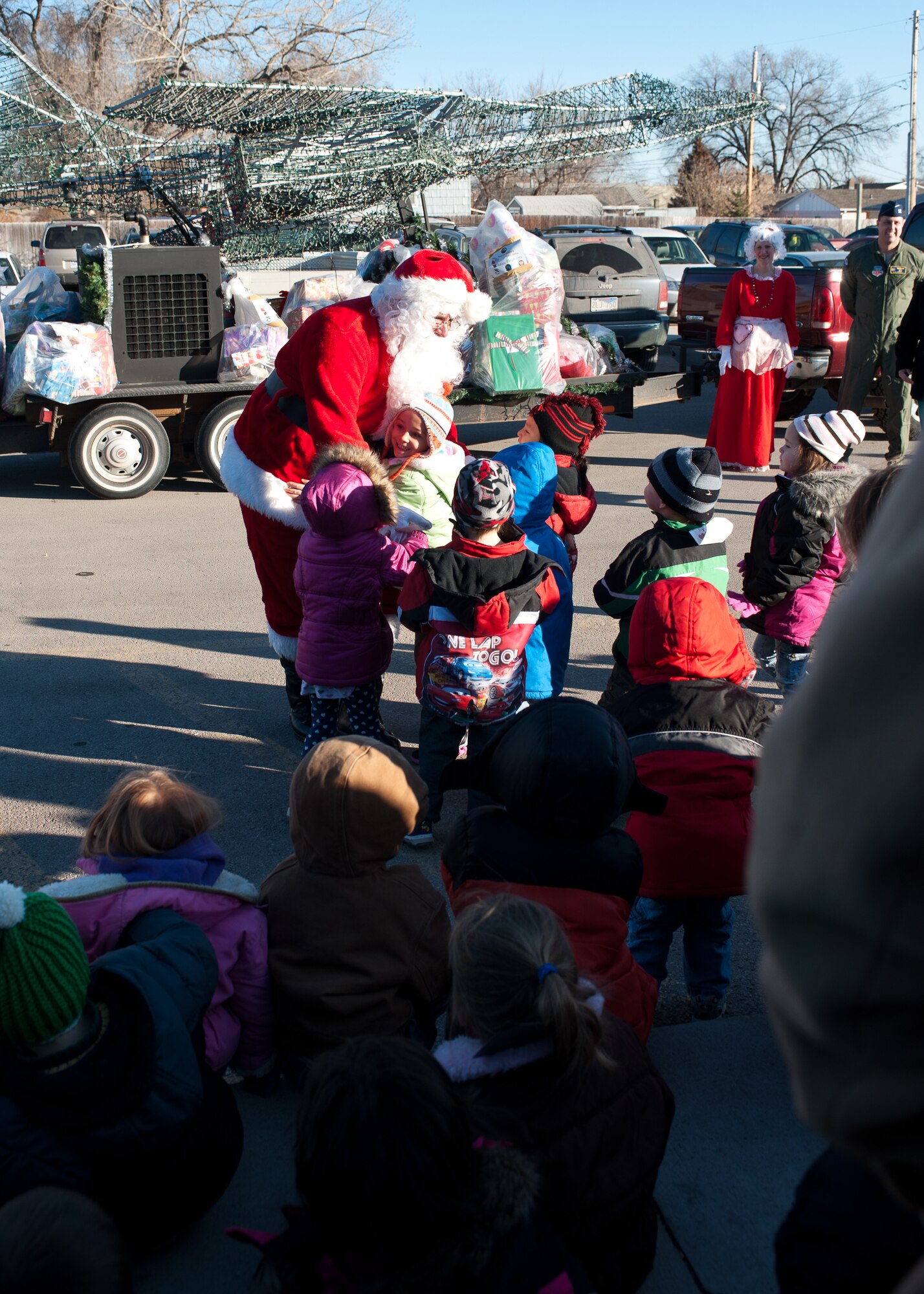 Children from the Youth & Family Services Child Care program in Rapid City, S.D. run up to greet Santa as he arrives aboard the Ellsworth Air Force Base, S.D. Festival of Lights parade float, Dec. 15, 2011. The 28th Operations Group invited Santa and Mrs. Claus to help hand out more than 180 gifts to the children as part of the 28th OG Angel Tree program.  (U.S. Air Force photo by Airman Alystria Maurer/Released)