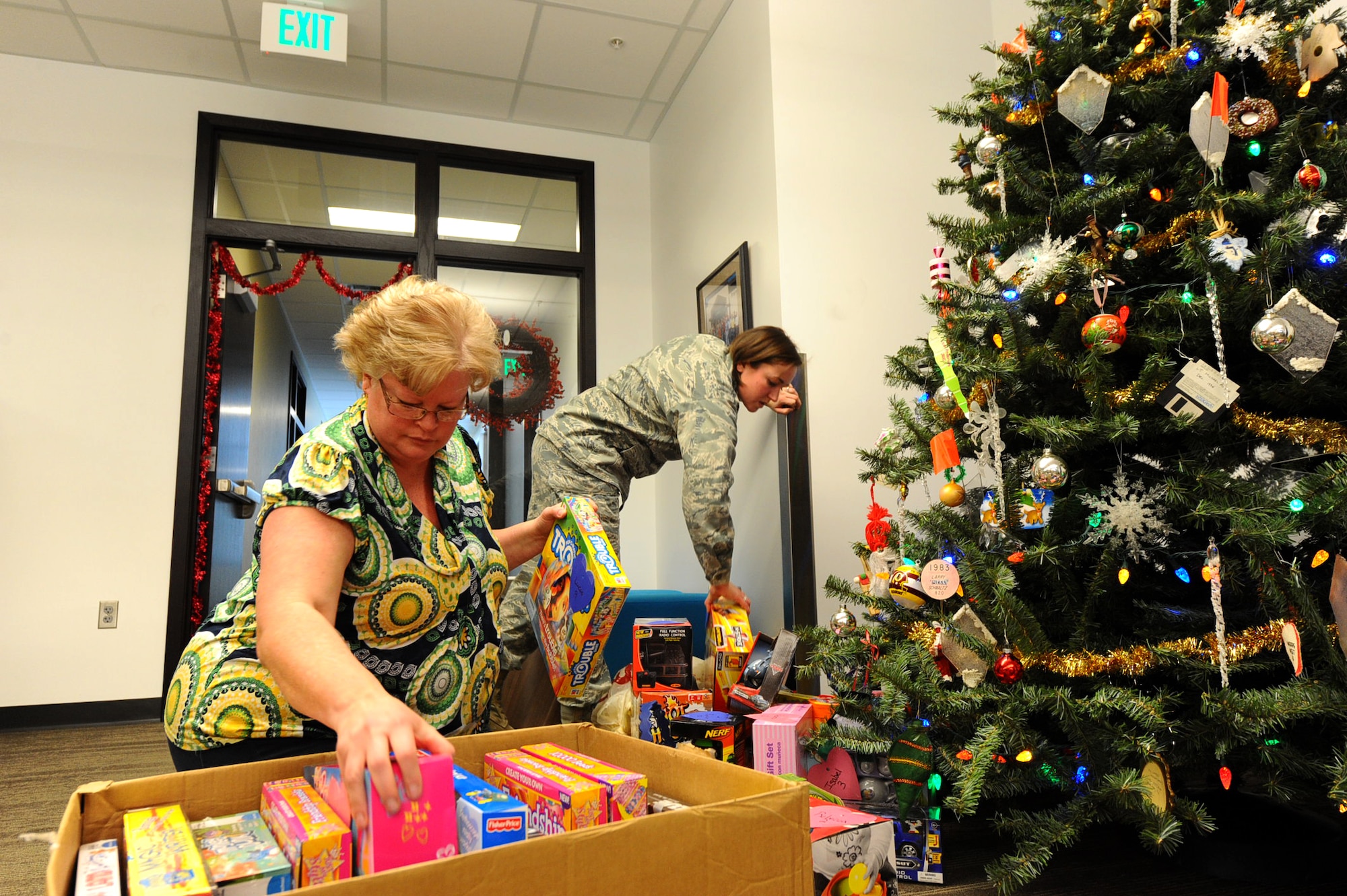 Stacey Heverly, 28th Civil Engineer Squadron office automation assistant, and 1st Lt. Rebecca Gehrman, 28th CES programs deputy flight chief, pack donated presents gathered during the annual Gifts from the Heart drive on Ellsworth Air Force Base, S.D., Dec. 13, 2011. The presents were packed up and delivered to the Douglas High School Junior Reserve Officer Training Corps program to be handed out to underprivileged children. (U.S. Air Force photo by Airman 1st Class Zachary Hada/Released)