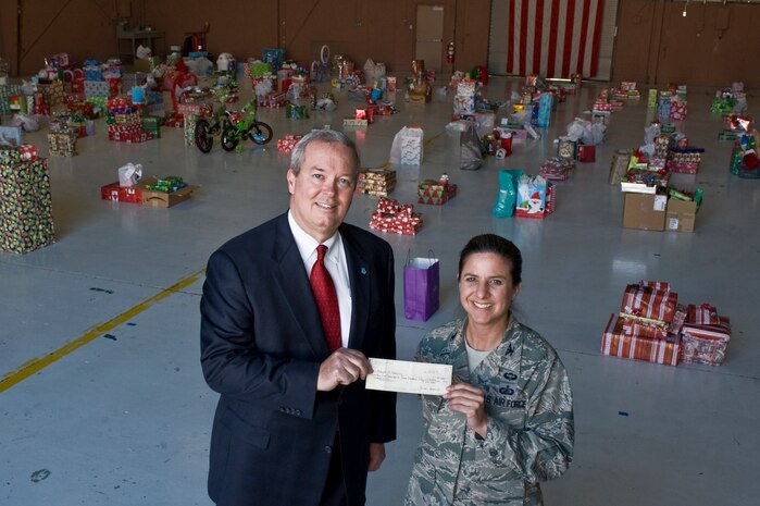 Randy Campanale, Nellis Support Team member, presents a check for $25,450 to Col. Carol Yannarella, 99th Air Base Wing vice commander, Dec. 13, 2011, at Nellis Air Force Base, Nev. The NST donation will support the base’s “Adopt a Family” program, which provided food and holiday gifts for nearly 250 military families, including more than 400 military children, during the 2011 holiday season. (U.S. Air Force photo by Airman 1st Class Daniel Hughes)