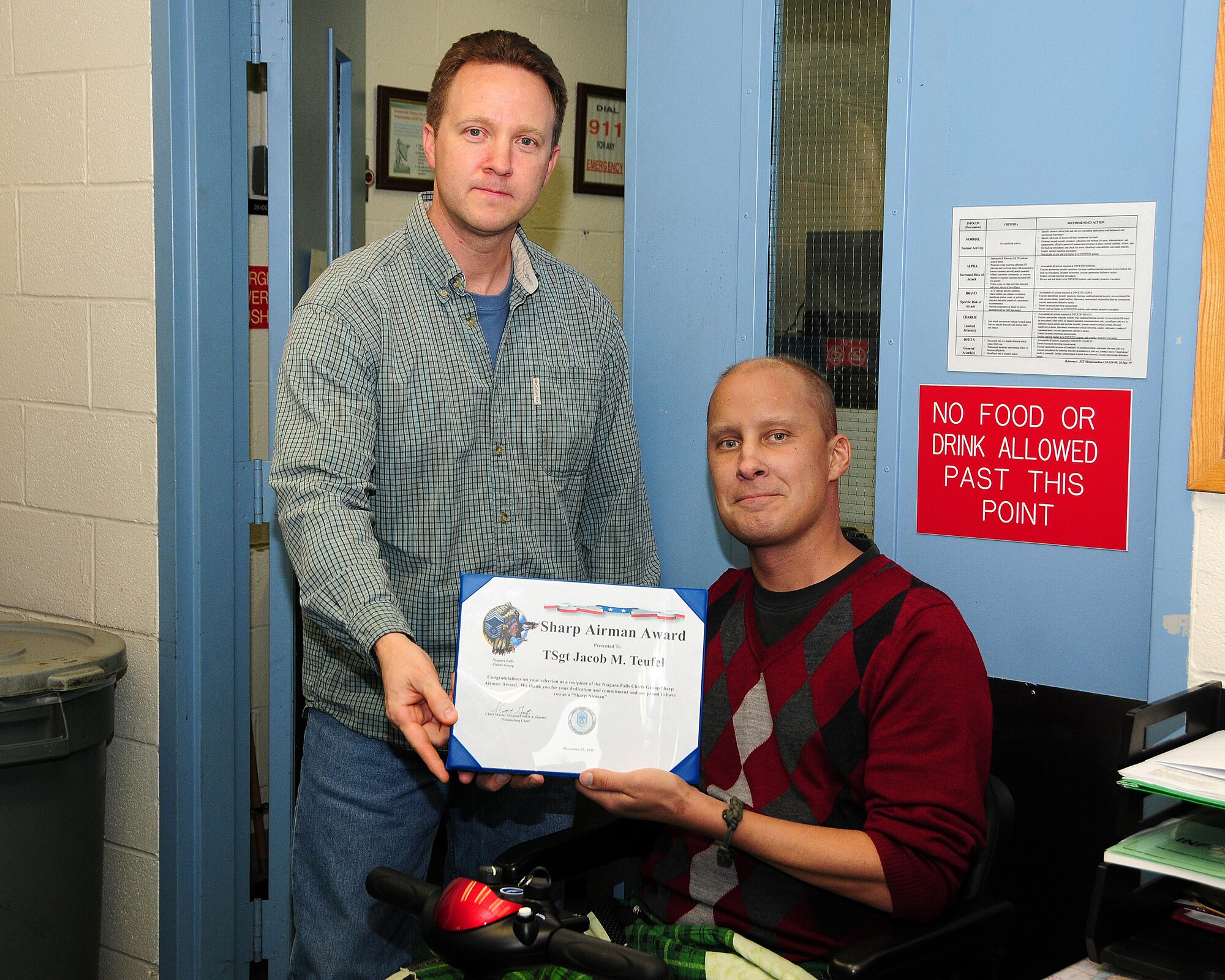 Chief Master Sgt. Scott Goetze (left), 914th Maintenance Operations Flight superintendent, presents Tech. Sgt. Jacob M. Teufel, 914th Maintenance Squadron hydraulics technician with the Sharp Airman Award during an informal gathering on December 22, 2011 at the Niagara Falls Air Reserve Station. The award is presented by the Niagara Falls Chief’s group to a Tech. Sgt. or below who demonstrates exemplary standards, appearance and professionalism on a continuous basis. Teufel has demonstrated all of those qualities while he continues to battle cancer. (U.S. Air Force photo by Peter Borys)