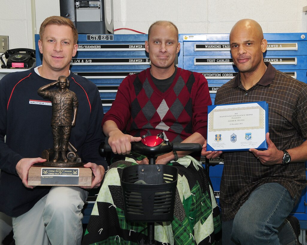 Lt. Col. Christopher Thurn, 107th Aircraft Maintenance Squadron commander (left) and Lt. Col. Kelvin McElroy, 914th Maintenance Group commander, (far right) pose with Tech. Sgt. Jacob Teufel, 914th Maintenance Squadron hydraulics technician with the 2011 Maintenance Excellence Trophy he received during an informal gathering at the Niagara Falls Air Reserve Station December 22. Teufel who is battling cancer is the first sole recipient to receive this joint 914 and 107 Airlift Wing award. (U.S. Air Force photo by Peter Borys)