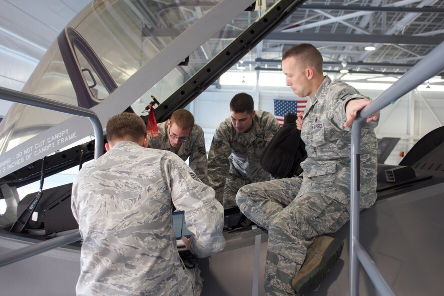 Staff Sgts. Jonathan Morris, Andrew Fries, Matthew Reed and Master Sgt. Scott Grabham, of the 58th Aircraft Maintenance Unit, receive training on F-35A crew station post operations inspections Dec. 12. They are part of the first group of military joint strike fighter maintainers at the 33rd Fighter Wing qualified in numerous F-35A flight inspections initially provided by contractor support. (U.S. Air Force photo/Staff Sgt. Jason Westberry) 