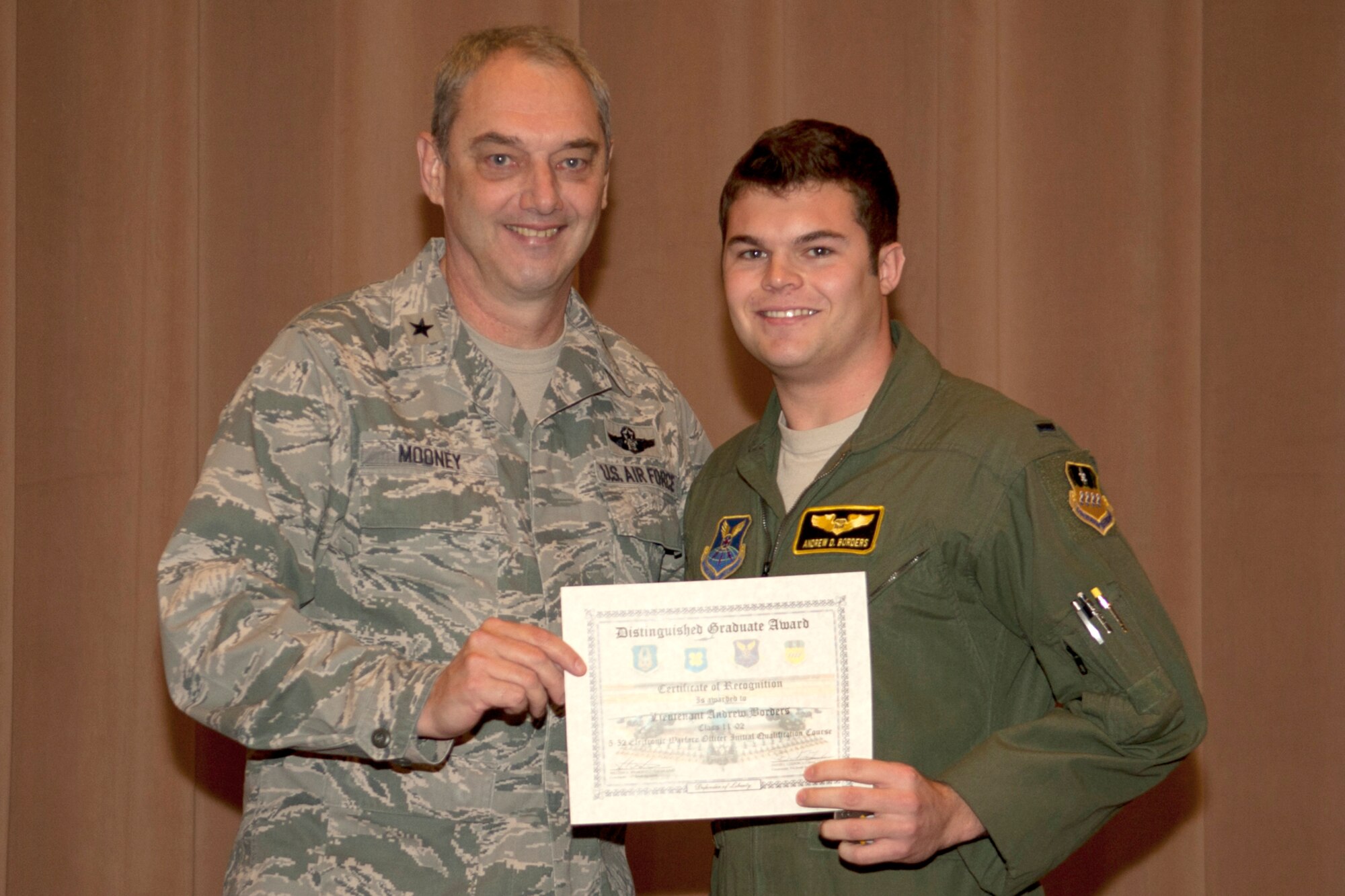 U.S. Air Force Brig. Gen. John Mooney III, 307th Bomb Wing commander, presents the Electronic Warfare Officer Distinguished Graduate certificate to 2nd Lt. Andrew Borders, Barksdale Air Force Base, La., Dec. 22, 2011. Borders is a graduate of the 93rd Bomb Squadron Formal Training Unit's B-52 aircrew training school.(U.S. Air Force photo by Master Sgt. Greg Steele/Released)