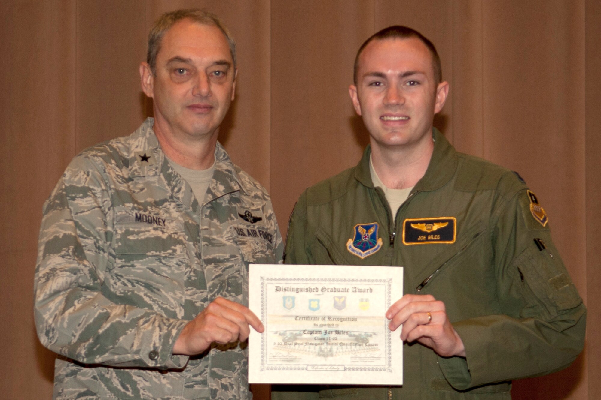 U.S. Air Force Brig. Gen. John Mooney III, 307th Bomb Wing commander, presents the Dual Seat Navigator Distinguished Graduate certificate to Capt. Joe Biles, Barksdale Air Force Base, La., Dec. 22, 2011. Biles is a graduate of the 93rd Bomb Squadron Formal Training Unit's B-52 aircrew training school.(U.S. Air Force photo by Master Sgt. Greg Steele/Released)