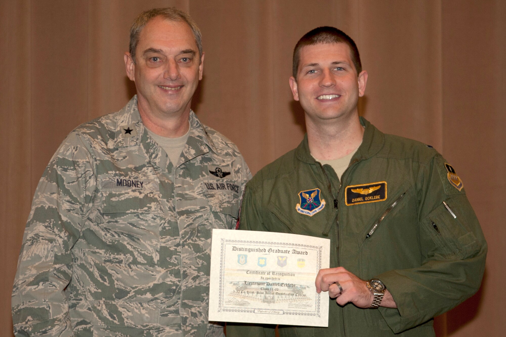 U.S. Air Force Brig. Gen. John Mooney III, 307th Bomb Wing commander, presents the Pilot Distinguished Graduate certificate to 2nd Lt. Daniel Ecklebe, Barksdale Air Force Base, La., Dec. 22, 2011. Ecklebe is a graduate of the 93rd Bomb Squadron Formal Training Unit's B-52 aircrew training school.(U.S. Air Force photo by Master Sgt. Greg Steele/Released)