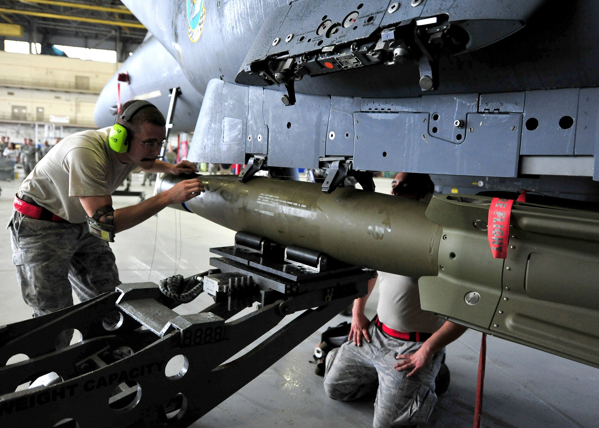 Staff Sgt. Kenneth Merritt, of the 46th Aircraft Maintenance Squadron, directs the loader to where the Guided Bomb Unit-12 goes during the 46th Maintenance Group’s fourth quarter weapons load competition at Eglin Air Force Base, Fla., Dec. 21. The best of Blue AMU and Red AMU met to load an AIM-9 and GBU-12 onto an F-16 and F-15 respectively. AMU Red won the competition. (U.S. Air Force photo/Randy Gon) 