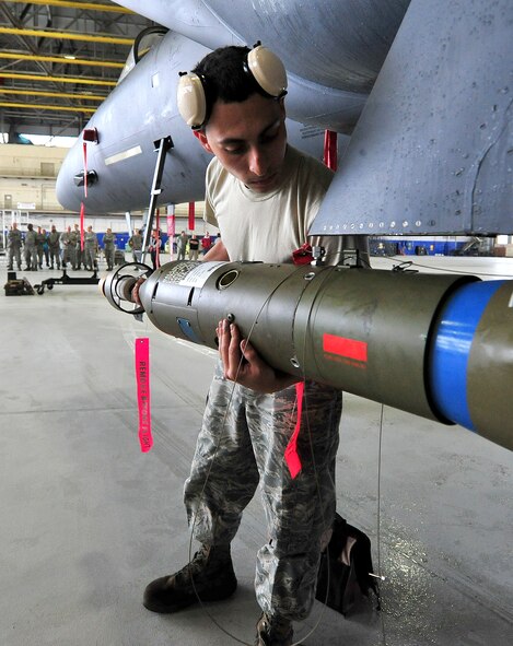 Senior Airman Hector Vazquez, from the 46th Aircraft Maintenance Squadron, adjusts the GBU-12 onto the aircraft during the 46th Maintenance Group’s fourth quarter weapons load competition at Eglin Air Force Base, Fla., Dec. 21. The best of Blue AMU and Red AMU met to load an AIM-9 and GBU-12 onto an F-16 and F-15 respectively. AMU Red won the competition. (U.S. Air Force photo/Randy Gon)