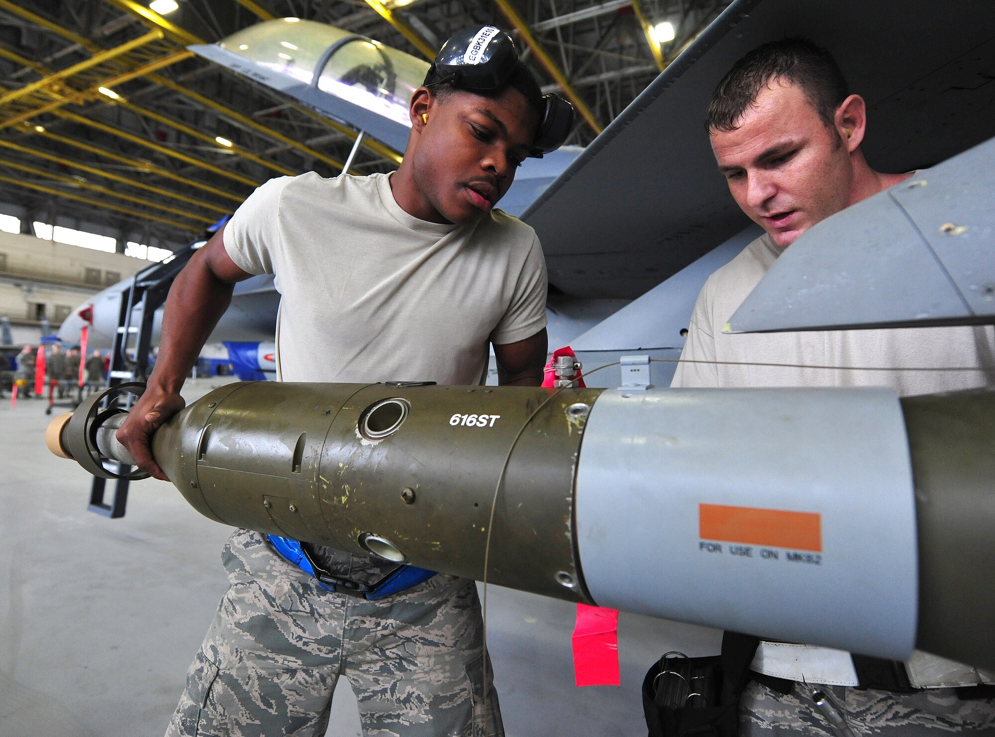 Airman 1st Class Adrian Justice, from the 46th Aircraft Maintenance Squadron, adjusts the GBU-12 onto the aircraft during the 46th Maintenance Group’s fourth quarter weapons load competition at Eglin Air Force Base, Fla., Dec. 21. The best of Blue AMU and Red AMU met to load an AIM-9 and GBU-12 onto an F-16 and F-15 respectively. AMU Red won the competition. (U.S. Air Force photo/Randy Gon)
