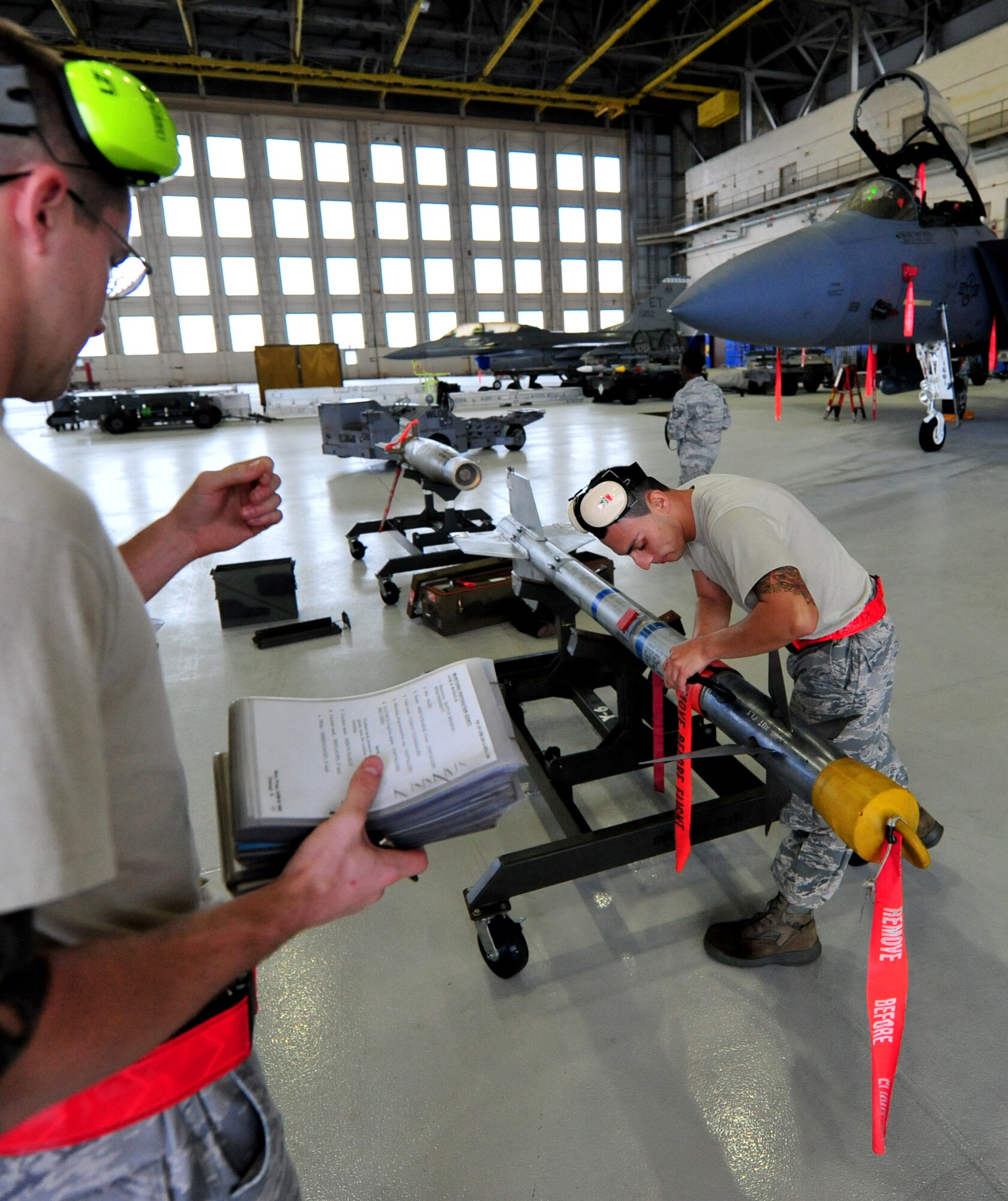 Senior Airman Hector Vasquez, with the 46th Aircraft Maintenance Squadron, readies the AIM-9 as crew leader Staff Sgt. Kenneth Merritt observes during the 46th Maintenance Group’s fourth quarter weapons load competition at Eglin Air Force Base, Fla., Dec. 21. The best of Blue AMU and Red AMU met to load an AIM-9 and GBU-12 onto an F-16 and F-15 respectively. AMU Red won the competition. (U.S. Air Force photo/Randy Gon) 