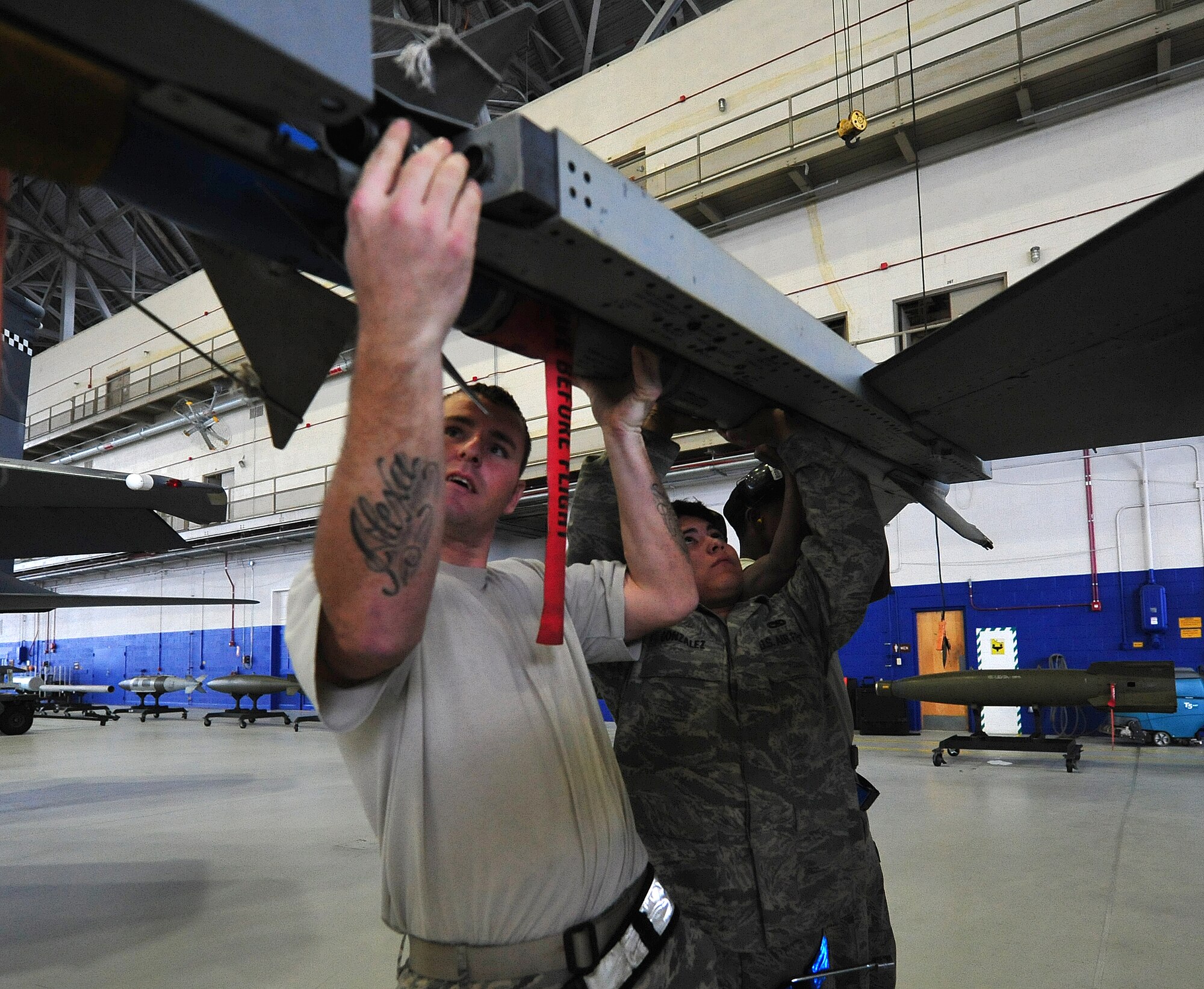 Staff Sgt. William Merritt, 46th Aircraft Maintenance Squadron crew leader, helps his Blue AMU team mount the AIM-9 during the 46th Maintenance Group’s fourth quarter weapons load competition at Eglin Air Force Base, Fla., Dec. 21. The best of Blue AMU and Red AMU met to load an AIM-9 and GBU-12 onto an F-16 and F-15 respectively. AMU Red won the competition. (U.S. Air Force photo/Randy Gon) 